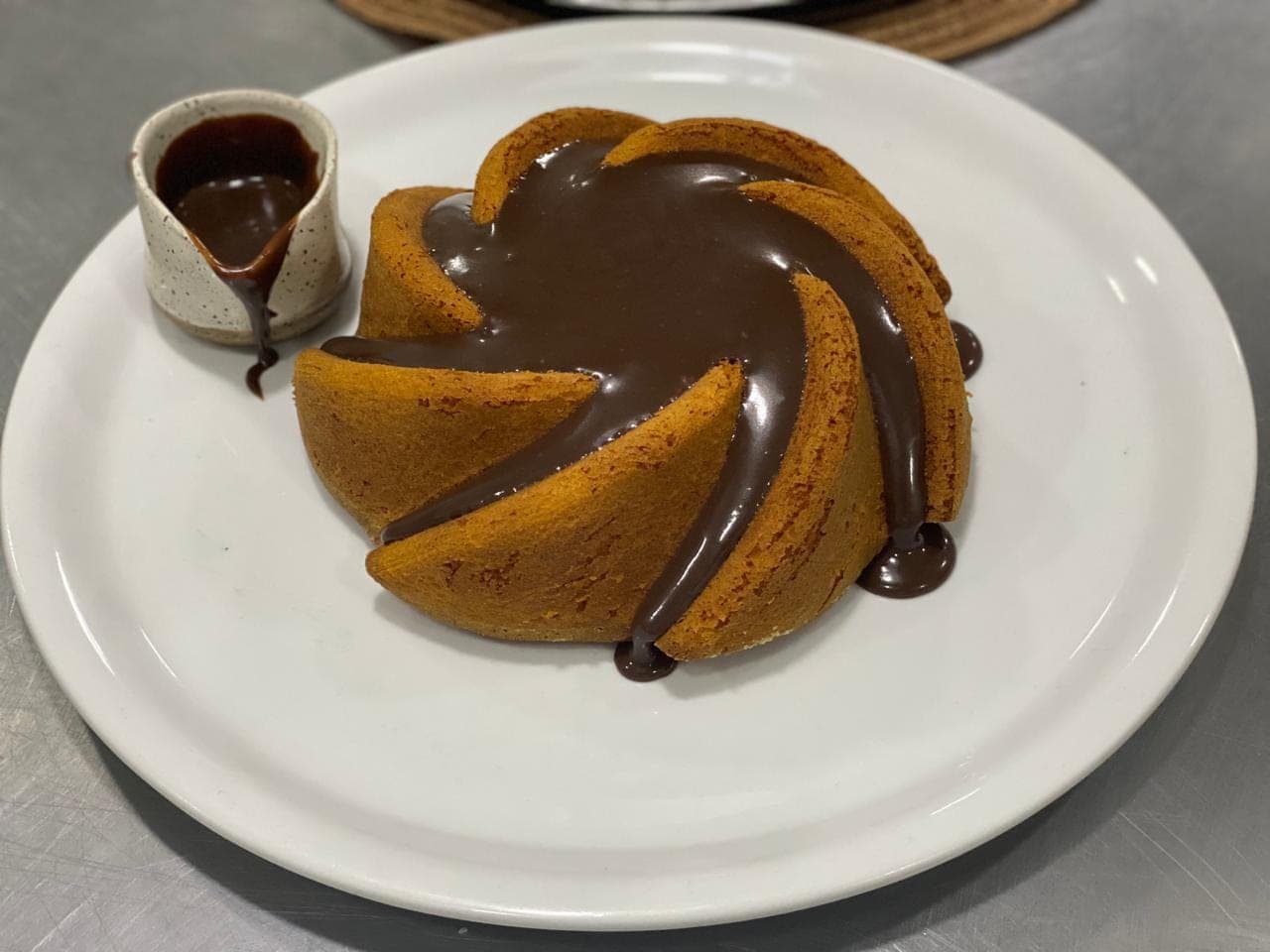 Bolo servido com calda de chocolate à parte