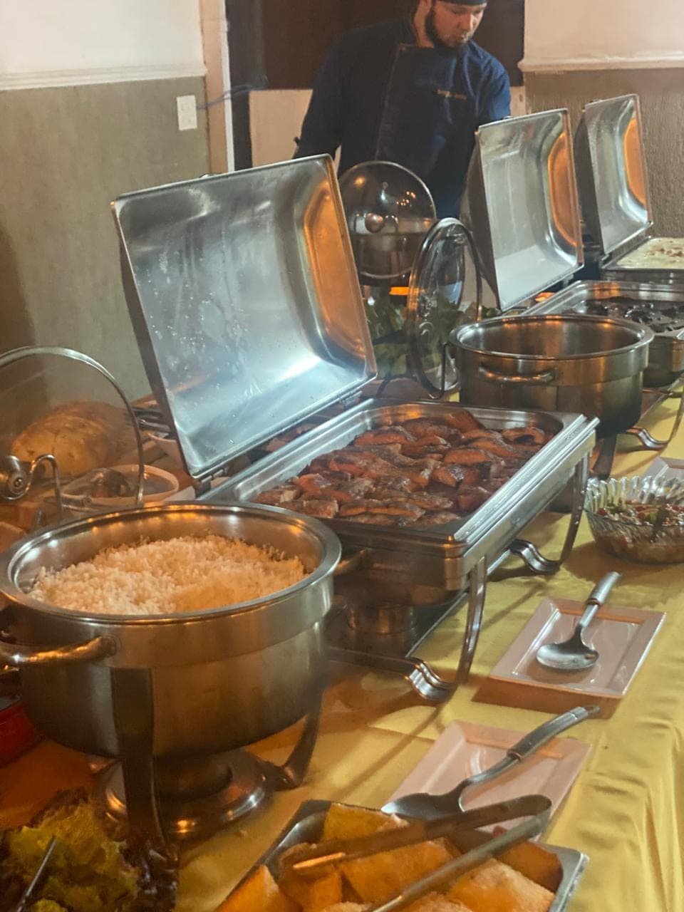 Panela de arroz e rechaud de carnes na linha de buffet do evento