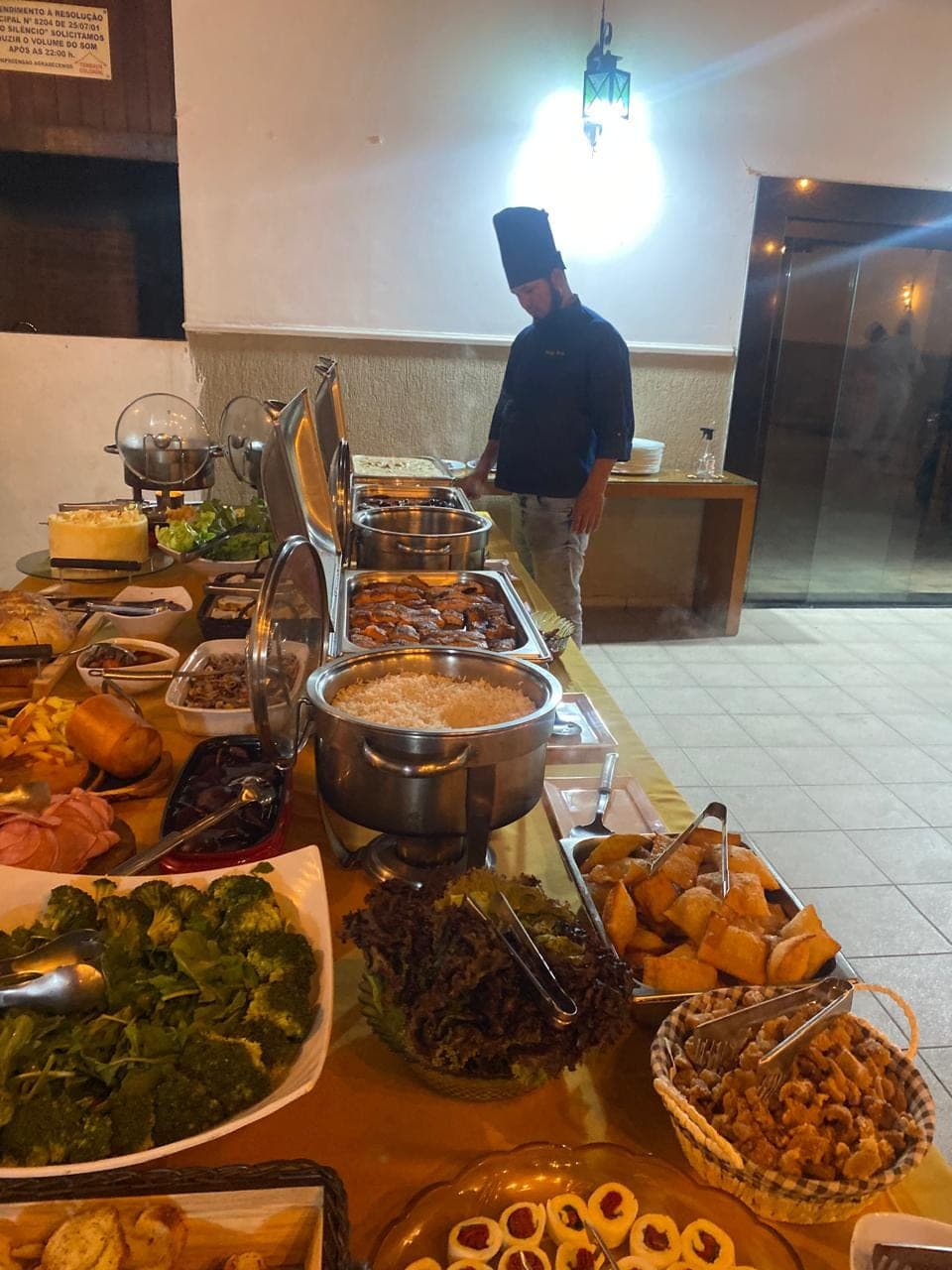 Buffet completo montado para evento, com saladas, legumes, pães e rechauds