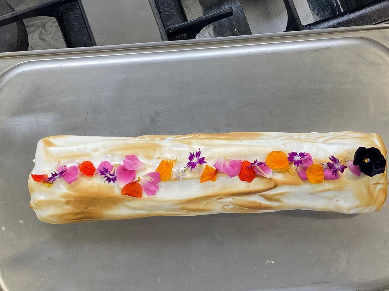 Rocambole merengado decorado com flores comestíveis