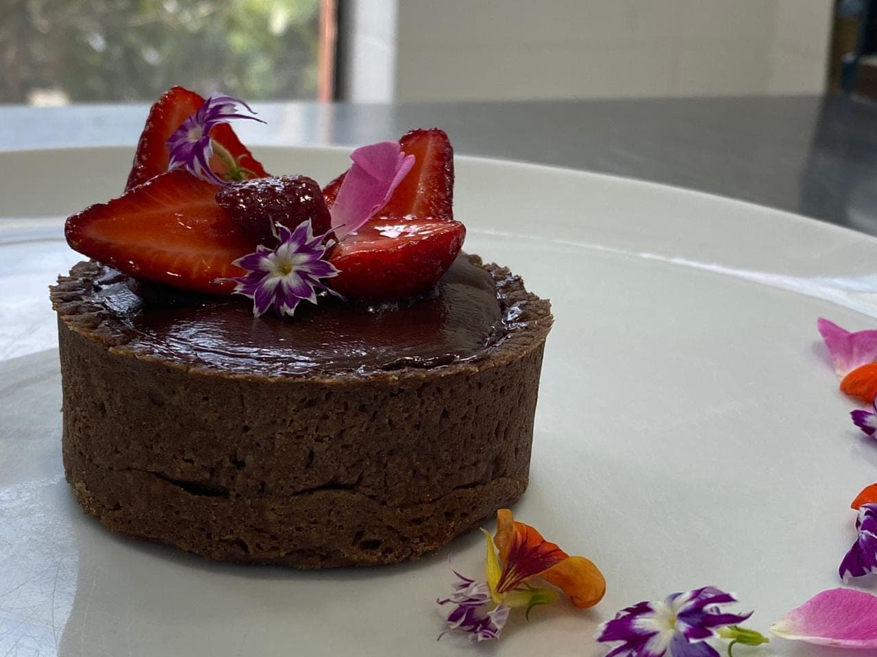 Torta de chocolate com morangos e flores comestíveis